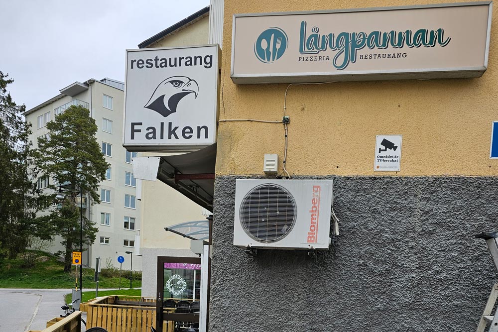 Utanför restaurangen som visar namnen Falken och Långpannan